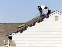 Man working on roof of house