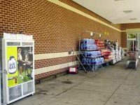 (Fig. 5.7) FDC in the cart area of a supermarket entryway.  The FDC is located where merchandise or shopping carts could easily block it, or a fire in the adjacent propane storage area could restrict its use.