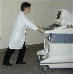 Sonographer using proper body mechanics to move ultrasound 
      equipment.