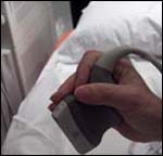 Operator holding transducer using a power grip.