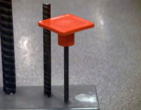 Steel rebar with a red steel enforced square cap