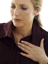 woman touching her chest in pain