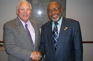 USADF President Lloyd Pierson shakes hand with AmbassadorCharles Minor after grant signing.