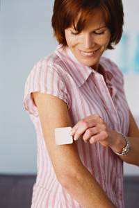 Picture of woman applying a nicotine patch to her arm