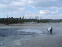 USGS scientists sampling Cynder Pool geyser in the Norris Basin of Yellowstone National Park, Wyoming, for dissolved mercury. Norris Basin is historically known for high sulfur and mercury levels.