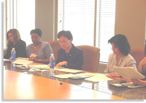 Director Shinae Chun and regional administrator Delores Crocket meet with women leaders at Burger King.
