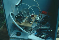 Bedrock wells at the site have packers that isolate the most permeable sections from each other. This is a view of an equipment box mounted on top of a well casing. Float-counterweight equipment is connected to a digital data acquisition system that records the hydraulic head in each section of the well. In this well there are three sections that are connected to the surface with PVC pipes