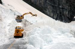 Heavy equipment remove snow and debris from Going-to-the-Sun Road.