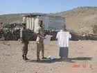 A DMAC shirt is presented to a village chief as a token of appreciation for his assistance in supporting Djiboutis mine risk education program. Photo by the RONCO Consulting Corporation.