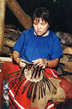 A Cherokee indian woman weaves a basket.