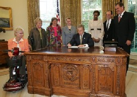 President George W. Bush signs an executive order for individuals with disabilities in emergency preparedness on July 22, 2004 in the Oval Office.