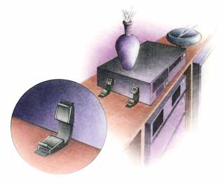 drawing of electronic device chassis held to the furnature top with straps.  The straps have release levers so the device can be removed and replaced without tools