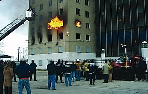 Photo showing members of a NIST research team watching flames erupt from an abandoned Chicago apartment building during a November 10, 2006 test of PPV in high-rise fires.