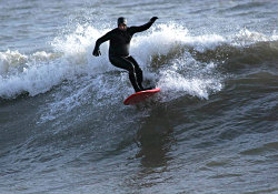 Vince Deur surfing across the Lake in Sheboygan, Wisconsin