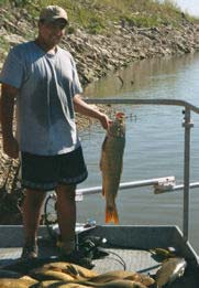 Photo of Lorenzo holding large Asian Carp near water