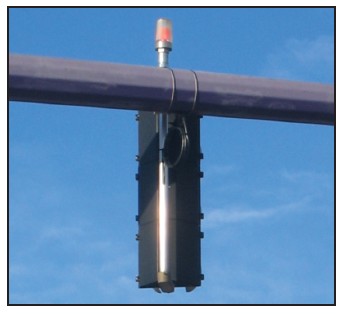 Photograph of a traffic signal with a red light mounted on top that can be seen from any angle when lit.