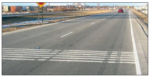 Photograph of rumble strips on the approach to an intersection.