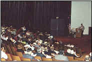 People sitting in auditorium listening to speaker