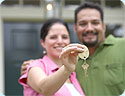 A happy man and woman; the woman is holding the keys to their new home.