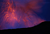 Incandescent parabolic arcs trace the path of ejecta cast out during explosions at the Waikupanaha ocean entry early Wednesday morning. This was a relatively small explosion, reaching a few tens of meters height, while the largest explosions this morning approached 70 meters in height. At the bottom of the photograph is the rim of the littoral cone built up by explosion deposits.