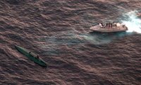 A boat interdicts a self-propelled semi-submersible vessel.