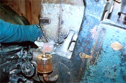 A worker manually adjusts tolerances of cutting heads with the machine running.