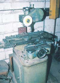 Unguarded abrasive wheel on saw blade sharpener machine. Note the lack of a local exhaust ventilation on wet system for dust generated during sharpening.