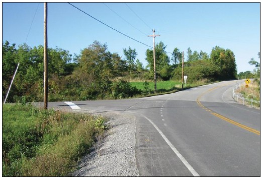 Photo depicting the use of a wide stop bar on the minor approach to an intersection within a horizontal curve.