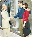 A man and woman shaking hands with a female realtor.