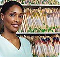 A woman standing in front of a shelf of medical files.