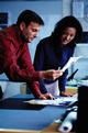 A man and a woman reviewing docs at a desk