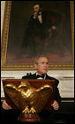 President George W. Bush, standing beneath a painting of President Abraham Lincoln, Sunday evening, Feb. 26, 2006 in the State Dining Room of the White House, welcomes guests to the State Dinner for the nation's governors.  White House photo by Kimberlee Hewitt