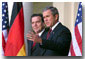 White House photo by Paul Morse. President George Bush and Germany's Chancellor Gerhard Schroeder address the media from the White House steps in the Rose Garden Oct 9.