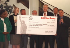 Officials hold over-sized presentation check. Click for larger image.