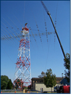 Workers with U.S. Tower Services mount the new Shared Resources (SHARES) High Frequency Radio antenna on top of its 125-foot tower structure last weekend in Arlington.  The newer, longer SHARES antenna will provide the National Communications System better SHARES radio coverage during emergency response events.