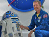 Astronaut Jim Reilly with R2-D2 and the Star Wars lightsaber.