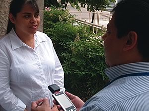 Photo showing a Census Bureau employee collecting information from a household using a hand-held computer.