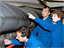 STS-114 crew members look at Discovery's wing leading edge
