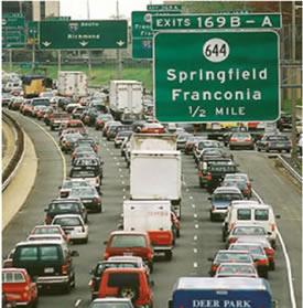 An image of vehicles on an interstate in congested traffic.