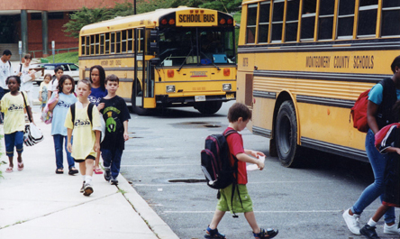 Children getting off school buses.