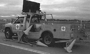 Photo depicts Advanced Cone Machine placing cones on a roadway.