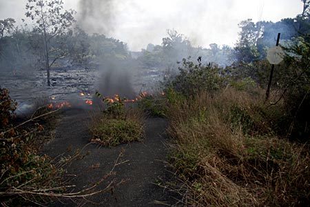 The steep, paved roads in Royal Gardens make easy pathways for lava. Here, lava flowing from left to right down Prince Avenue crosses Pikake Street in the foreground.