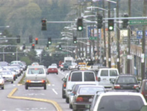 An image showing vehicles traveling through multiple traffic signals along a busy roadway.