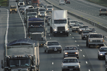 Photograph showing cars and trucks traveling in three lanes of traffic