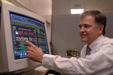 A visually impaired man uses a special devise to view his computer monitor.