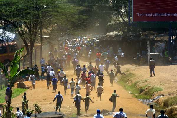 Kenyan protesters run from riot police in Nairobi after January 2008 elections.  AP Photo.
