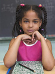Photo: Girl in classroom sitting at her desk