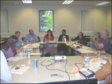 Figure 1: This is a photograph which shows attendees at the peer exchange sitting around a table discussing their state's programs.