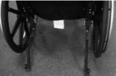 Close-up photograph of rear of wheelchair, showing anti-tip wheels, which also contribute to maneuverability.