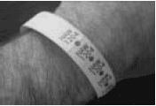 Photograph of a patient wristband with multiple, peel-off, adhesive labels.